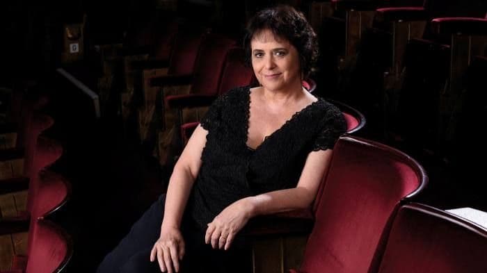 Nica Burns sitting in red theatre seats